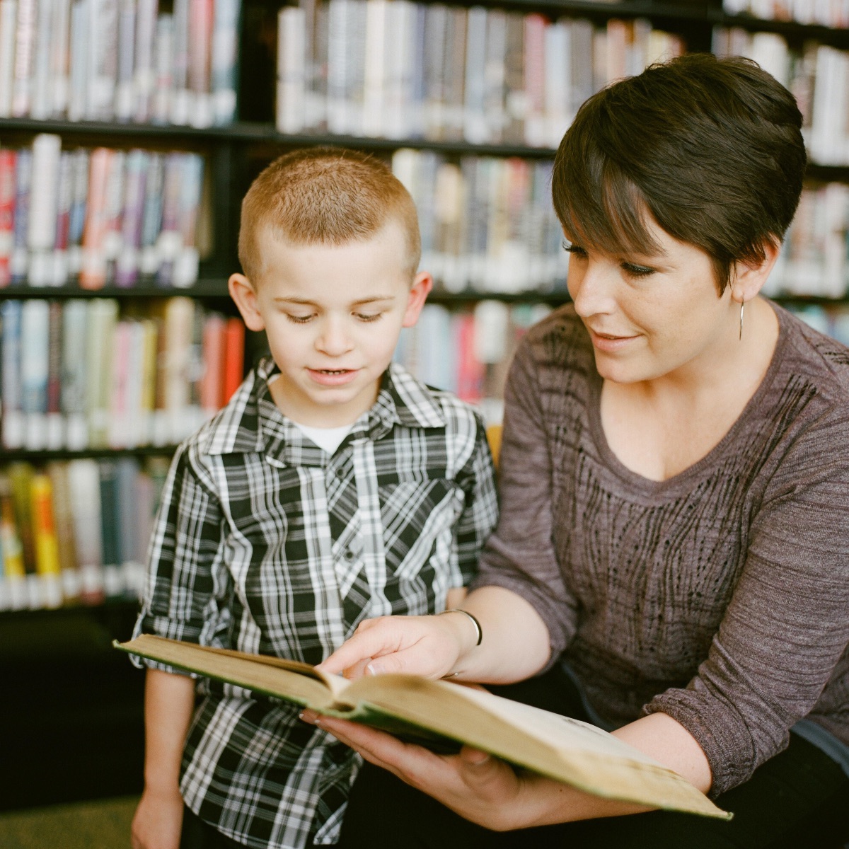 Mother reading to her son as he listens intently.